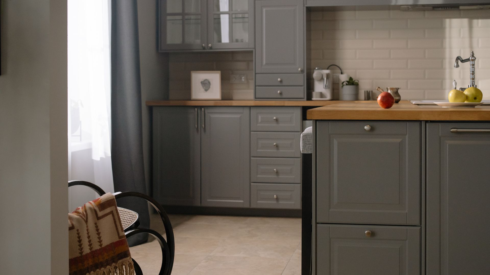 Modern gray kitchen with wooden countertop and fruits on surface