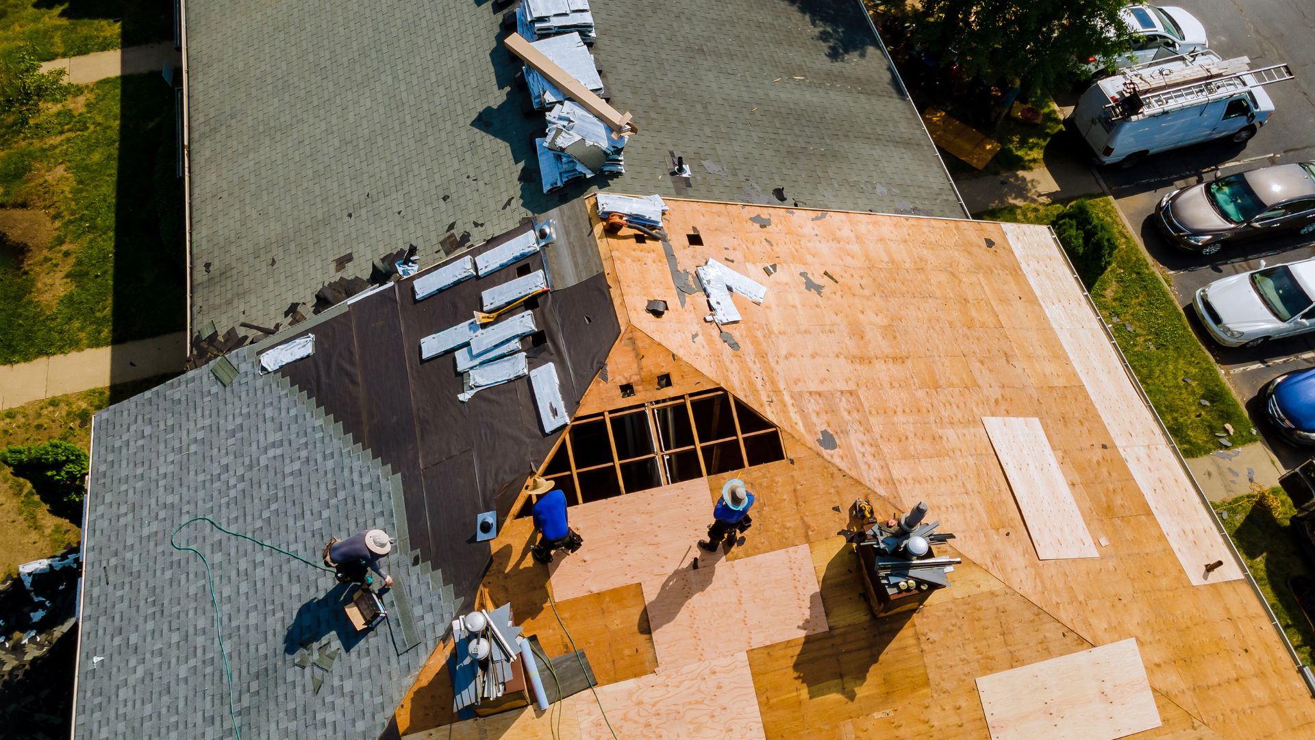 Aerial view of workers installing wooden roof shingles on house