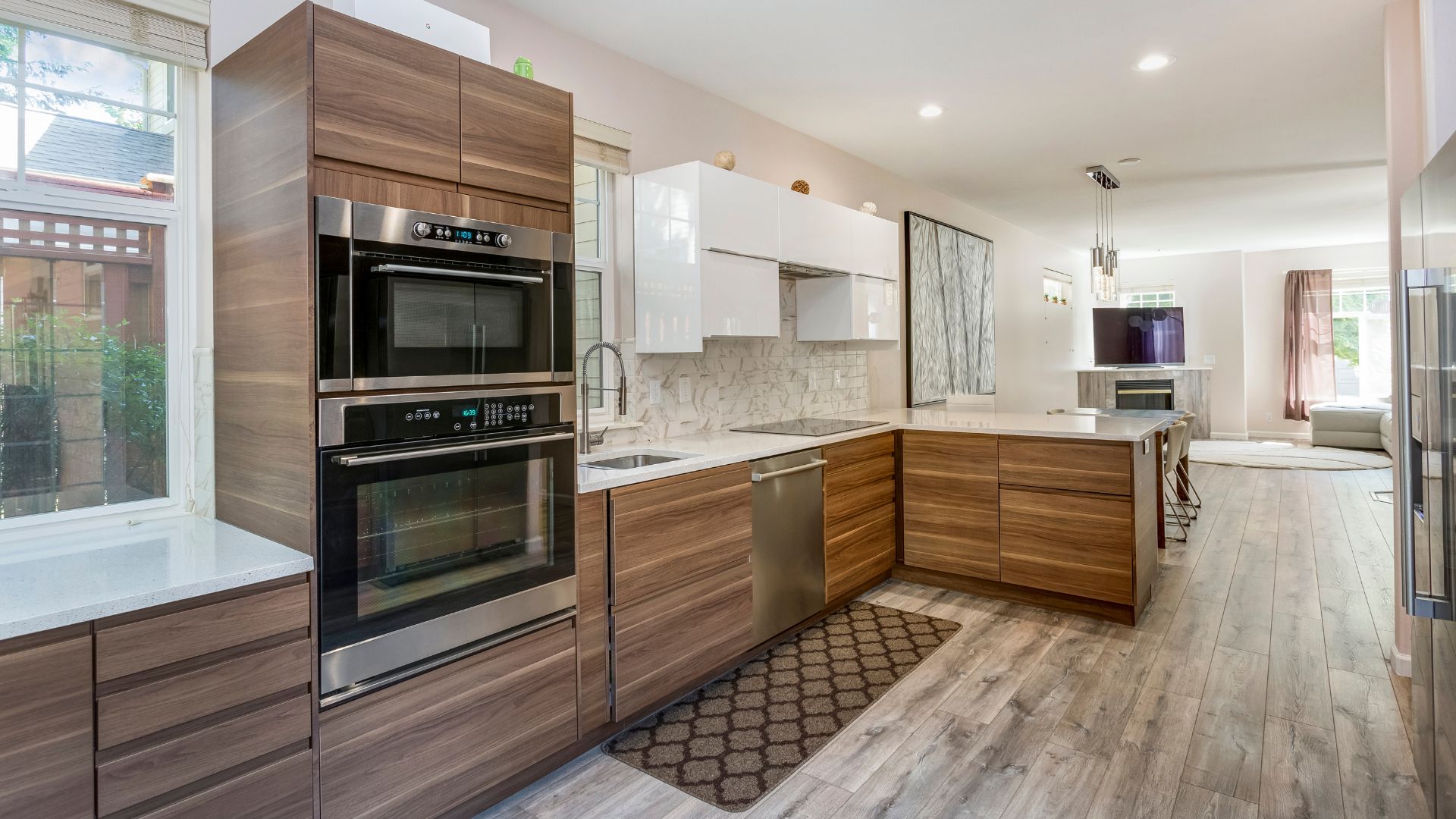 Modern kitchen with wood cabinets, white counters, and stainless steel appliances