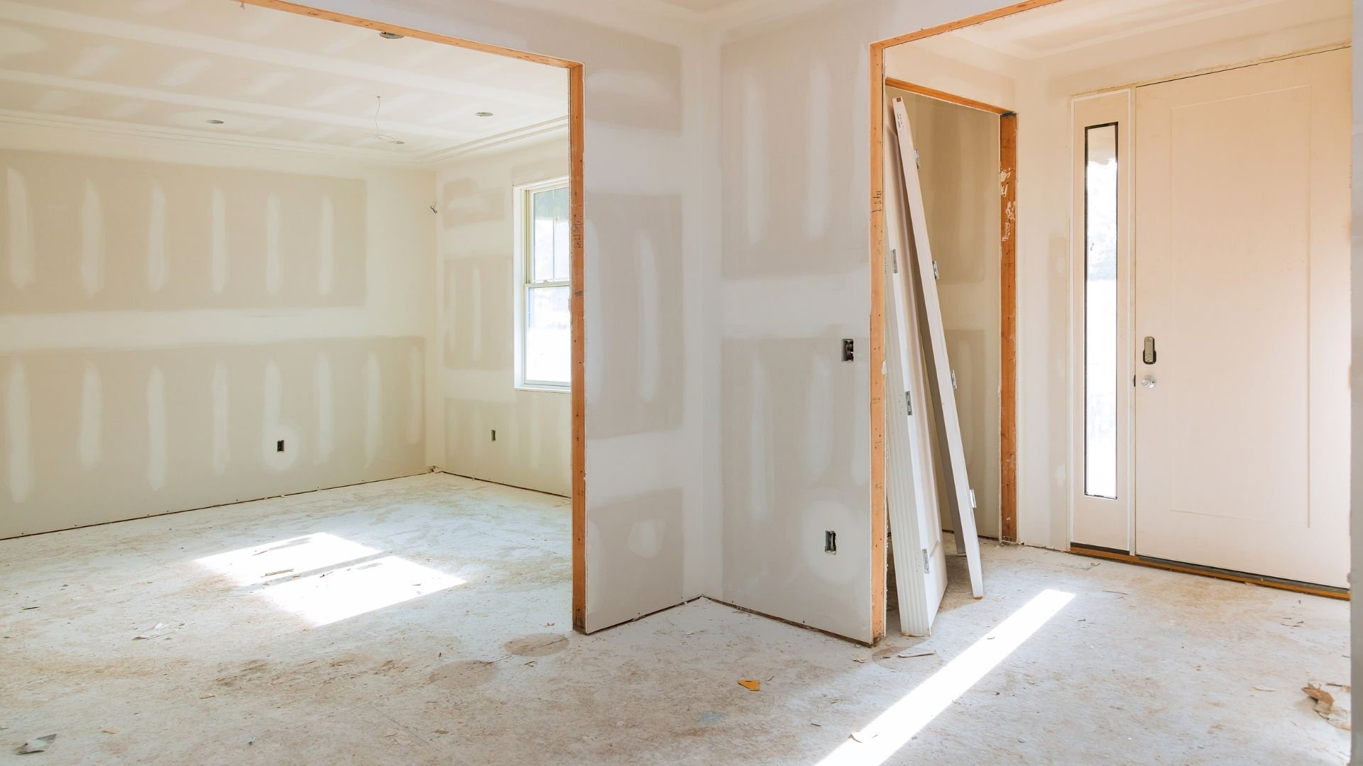 Interior of unfinished room with drywall, wooden frames, and construction materials