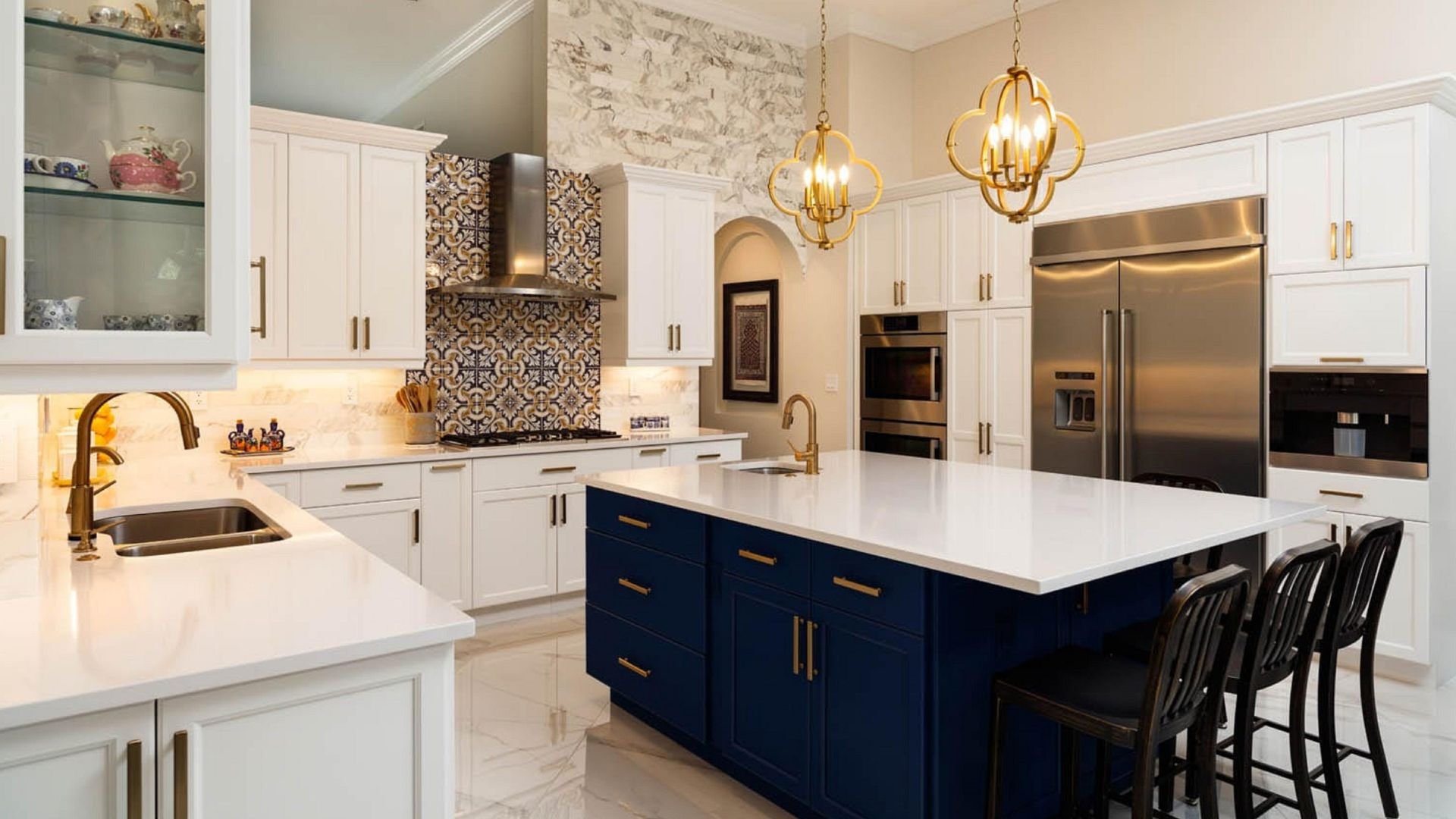 Modern kitchen with white cabinets, blue island, and golden light fixtures